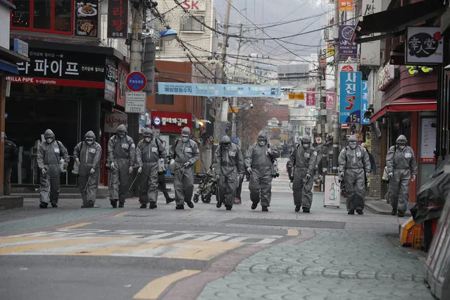 South Korean soldiers spray disinfectant in the street as a precaution against the spread of the novel coronavirus, in Seoul, South Korea, 04 March 2020. With over 5,000 cases of coronavirus reported, South Korea currently accounts for the largest number of infections outside mainland China. (Photo by Jeon Heon-Kyun/EPA/EFE)