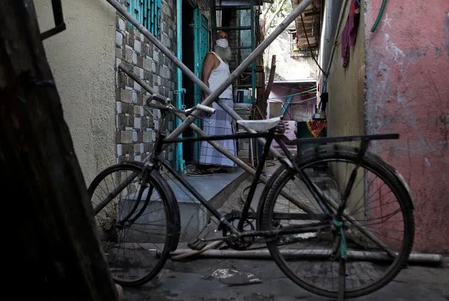 A man stands behind a makeshift barricade set up to stop people from entering a lane, during a nationwide lockdown in India to slow the spread of COVID-19, in Dharavi, one of Asia's largest slums, during the coronavirus disease outbreak, in Mumbai, India, April 9, 2020. (Photo by Francis Mascarenhas/Reuters)