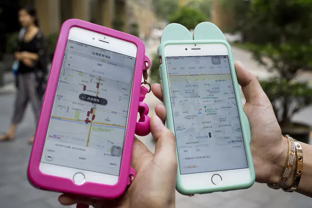Women holding their smartphones show the ride-hailing apps Uber Technology Ltd., left, and Didi Chuxing at a residential compound in Beijing, Monday, August 1, 2016. Uber Technology's main Chinese rival, Didi Chuxing, says it is acquiring the U.S. ride-hailing service's China operations, linking the companies in a business alliance after a costly battle for market share. Monday's announcement marked a surrender by another foreign technology brand to intense competition in China. (Photo by Andy Wong/AP Photo)