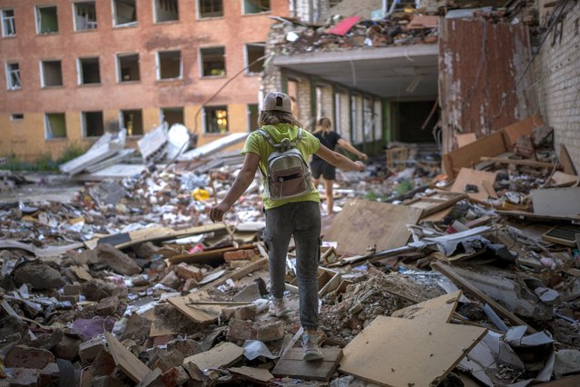 Student Karina Muzyka walks on the rubble of the Chernihiv School #21, which was bombed by Russian forces on the 3rd of March, in Chernihiv, Ukraine, Monday, August 29, 2022. (Photo by Emilio Morenatti/AP Photo)