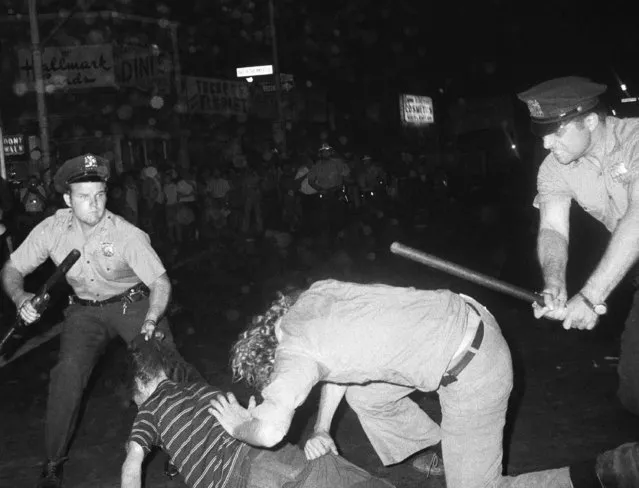 In this August 31,1970 file photo, an NYPD officer grabs a youth by the hair as another officer clubs a young man during a confrontation in Greenwich Village after a Gay Power march in New York. As Pride weekend approaches, the recent decision by organizers of New York City's event to ban LGBTQ police officers from marching in future parades while wearing their uniforms has put a spotlight on issues of identity and belonging, power and marginalization.For some, cops shouldn't have a visible presence at a march that commemorates the 1969 Stonewall uprising, sparked by a police raid on a gay bar. (Photo by AP Photo/File)