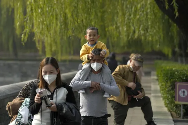 Visitors wear masks as visit the Forbidden city in the Tiananmen area where the upcoming 20th Community Party Congress will be held in Beijing, Friday, October 14, 2022. (Photo by Ng Han Guan/AP Photo)