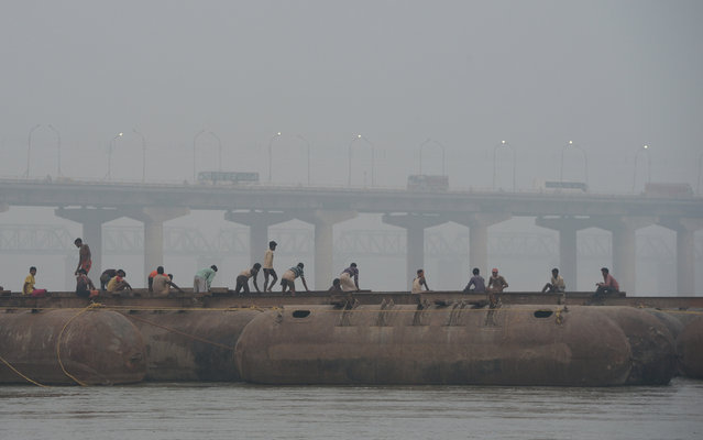 Indian labourers build a floating pontoon bridge over the river Ganges for the upcoming Magh Mela festival in Allahabad on November 9, 2017. The Magh Mela is held every year on the banks of Triveni Sangam – the confluence of the three great rivers Ganga, Yamuna and the mystical Saraswati – in Prayag near Allahabad during the Hindu month of Magh which corresponds to mid January – mid February. (Photo by Sanjay Kanojia/AFP Photo)