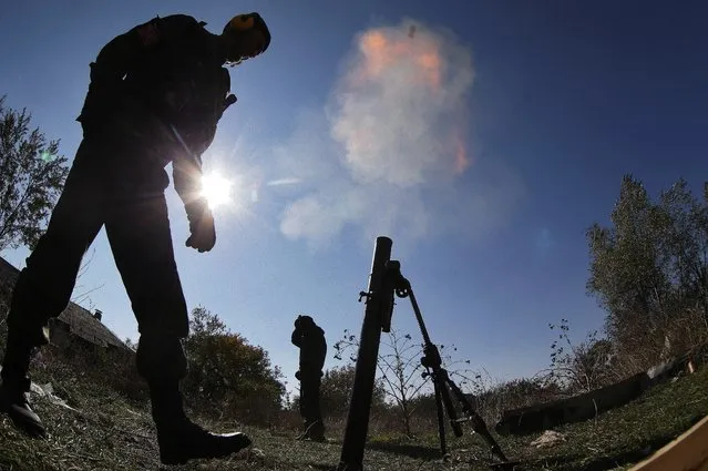 Pro-Russian rebels fire mortars toward Ukrainian position near to the airport in the town of Donetsk, eastern Ukraine, Thursday, October 9, 2014.  Donetsk airport is the focus of much of the fighting but has no immediate tactical significance for separatist forces who are devoid of any air power. (Photo by Dmitry Lovetsky/AP Photo)