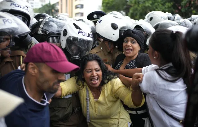 Anti government protesters scuffle with police officers as police blocked their protest march in Colombo, Sri Lanka, Wednesday, November 2, 2022. (Photo by Eranga Jayawardena/AP Photo)