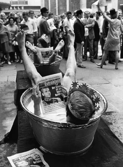 Protesters sit in bath tubs and read copies of an “Extrablatt” (Special Issue) of the satirical newspaper “Pardon” during an event organized by “Pardon” on August 3, 1967 in Frankfurt, Germany. Activists criticize the demands of the Shah of Persia that Shah opponents in Germany should be punished. The bath tubs are a mock up of the golden tubs that where allegedly given as present to the Shah and his wife by the German Government. (Photo by AP Photo)