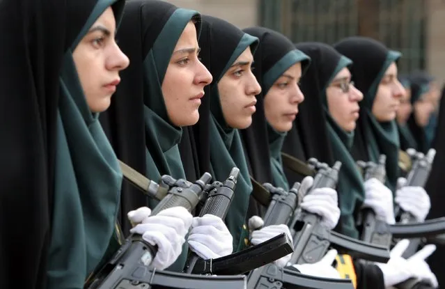 Iranian female police officers, wearing chadors stand at attention, with their assault rifle, during a female police graduation ceremony at the Police Academy in Tehran, Iran, Saturday, March, 11, 2006. (Photo by Vahid Salemi/AP Photo)