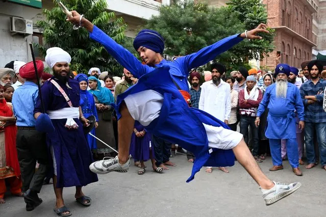 A Sikh youth performs “Gatka”, an ancient form of Sikh martial arts, during a religious procession on the eve of the birth anniversary of Guru Nanak Dev, at the Golden Temple in Amritsar on November 7, 2022. (Photo by Narinder Nanu/AFP Photo)