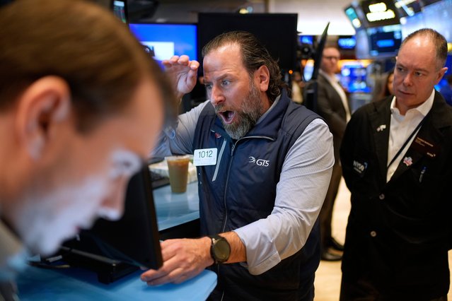 Mike Pistillo Jr., center, works with other traders on the floor at the New York Stock Exchange in New York, April 3, 2025. (Photo by Seth Wenig/AP Photo)