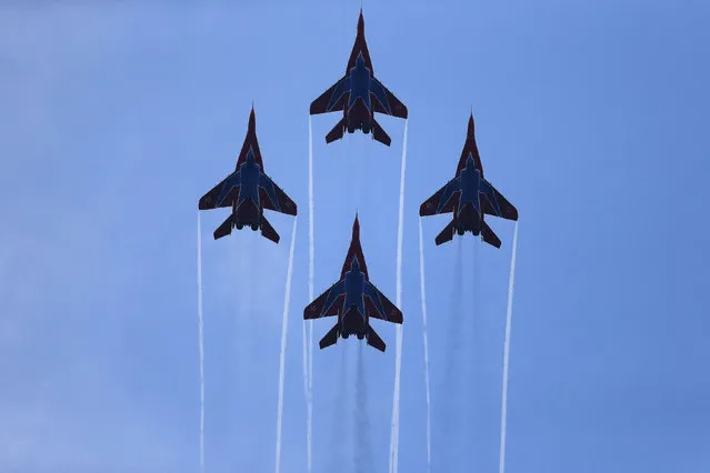 Russian aerobatic team Strizhi (The Swifts) performs on MIG-29s during a military parade to mark 70 years since the city's liberation by the Red Army in Belgrade October 16, 2014. Serbia feted Russia's Vladimir Putin with troops, tanks and fighter-jets on Thursday to mark seven decades since the Red Army liberated Belgrade, balancing its ambitions of European integration with enduring reverence for a big-power ally deeply at odds with the West. (Photo by Marko Djurica/Reuters)