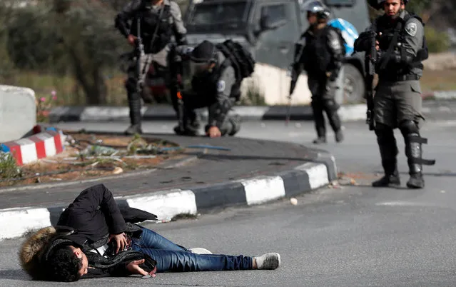 Israeli border policemen stand away after shooting a Palestinian man with a knife and what looks like an explosive belt near the Jewish settlement of Beit El, near the West Bank city of Ramallah. December 15, 2017. (Photo by Goran Tomasevic/Reuters)