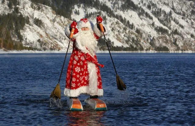 Nikolai Vasilyev, 64, dressed as Father Frost, the Russian equivalent of Santa Claus, water-skis along the Yenisei River outside the Siberian city of Krasnoyarsk, Russia December 19, 2017. Vasilyev, former teacher of the Siberian State Aerospace University, constructed the water skis out of plastic foam and designed the sticks to propel him forward, while travelling on the water surface. (Photo by Ilya Naymushin/Reuters)