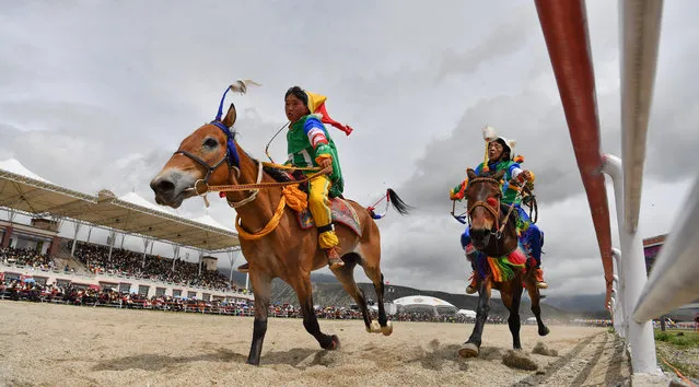 Riders compete during a horse race at the Dangjiren horse racing festival in Damxung County, southwest China's Tibet Autonomous Region, August 10, 2020. (Photo by Xinhua News Agency/Rex Features/Shutterstock)