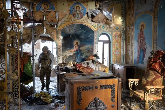 A Ukrainian soldier with the Karpatska Sich Battalion in a church that was destroyed by shelling and looted by the Russian military during their occupation of Lyman, in the Donetsk region of eastern Ukraine, on Christmas Day, Sunday, December 25, 2022. (Photo by Tyler Hicks/The New York Times)