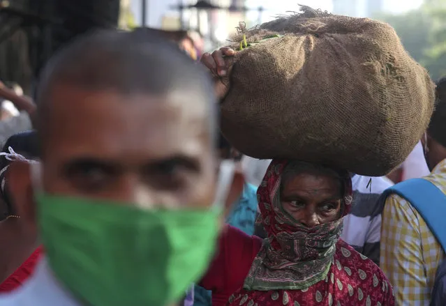 A woman arrives to sell vegetables in a market in Mumbai, India, Saturday, September 12, 2020. Millions lost their jobs, and thousands, fearing starvation, poured out of cities to try and get back to their rural homes during India's lockdown of 1.3 billion people earlier this year. The economy shrunk by nearly 24% in the last quarter, the most of any major country. (Photo by Rafiq Maqbool/AP Photo)