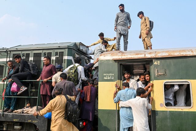Pakistanis board a train at a railway station in Lahore on June 5, 2025, to travel to hometowns ahead of Eid al-Adha. (Photo by Arif Ali/AFP Photo)