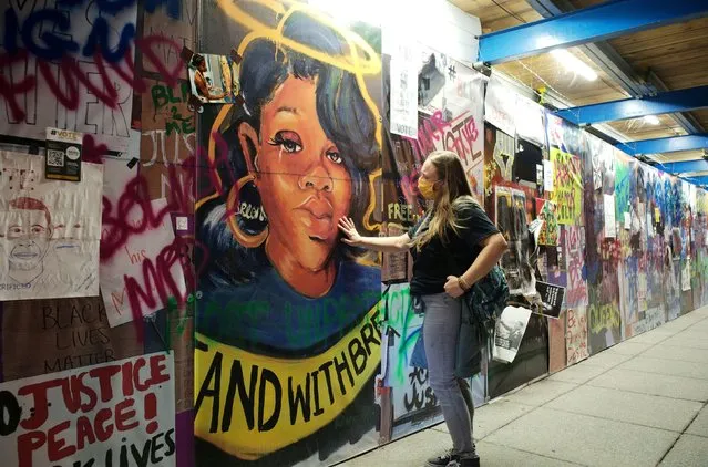 A woman pays homage as she touches a Breonna Taylor mural, the day after a grand jury voted to indict one of three white police officers for Taylor's death, at Black Lives Matter Plaza in Washington, U.S., September 24, 2020. (Photo by Cheriss May/Reuters)