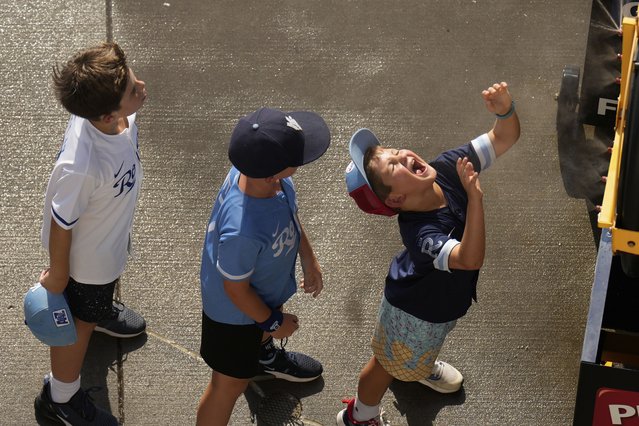 Kids cool off in a mister at Kauffman Stadium before a baseball game between the Kansas City Royals and the Atlanta Braves as temperatures approach the 100 degrees, Tuesday, July 29, 2025, in Kansas City, Mo. (Photo by Charlie Riedel/AP Photo)