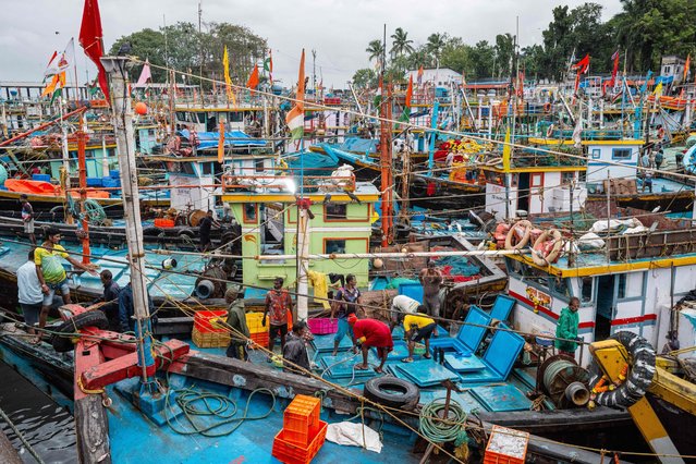 Fishermen offload fresh seafood from a boat early morning at the Sassoon Dock in Mumbai on August 13, 2025. Indian exporters are scrambling for options to mitigate the fallout of US President Donald Trump's threatened tariff salvo against the world's most populous nation. The 50 percent levy threatens to upend low-margin, labour-intensive industries ranging from gems and jewellery to textiles and seafood. (Photo by Punit Paranjpe/AFP Photo)