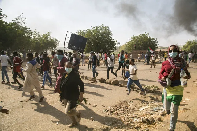 Protesters run as security forces intervene in protesters with tear gas during a protest against economic crisis and high cost of living in Khartoum, Sudan on October 21, 2020. (Photo by Mahmoud Hjaj/Anadolu Agency via Getty Images)