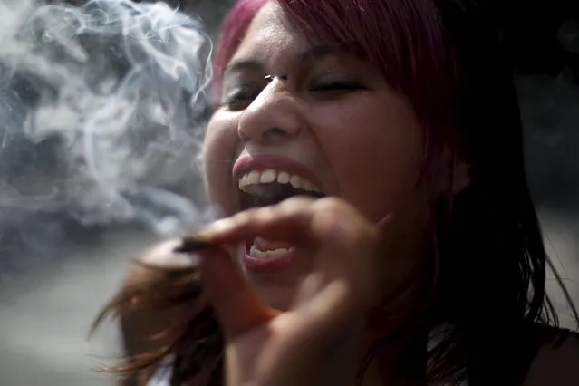A woman smokes as she smiles during a demonstration in support of the legalization of marijuana outside the Supreme Court building in Mexico City, Mexico, November 4, 2015. Mexico's Supreme Court on Wednesday gave the green light to growing marijuana for recreational use in a landmark decision that could lead to legalization in a country with a bloody history of conflict with drug cartels. (Photo by Edgard Garrido/Reuters)