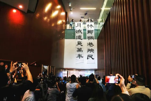 Pan-democratic legislator Lam Cheuk-ting hangs a banner that reads “Carrie Lam harms Hong Kong and its people, stinks for ten thousand years” at the legislature in Hong Kong, China on November 12, 2020. Hong Kong's opposition staged a final show of defiance before resigning to protest against the dismissal of four of their colleagues in what they see as another bid by Beijing to suppress democracy in the city. The withdrawal of the opposition from the city legislature will mean an end for what has been one of the few forums for dissent after Beijing's imposition of national security legislation in June and coronavirus restrictions ended pro-democracy protests that began last year. (Photo by Tyrone Siu/Reuters)