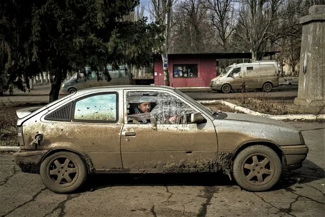 A man looks on as he sits inside a damaged car in the village of Chasiv Yar on March 11, 2023 amid the Russian invasion of Ukraine. (Photo by Aris Messinis/AFP Photo)
