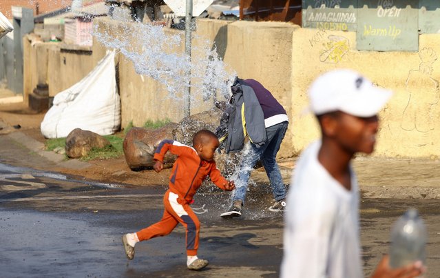 A child runs as locals pour water on one another during Spring Day celebration in Protea North, a suburb west of Johannesburg, South Africa, on September 1, 2025. (Photo by Siphiwe Sibeko/Reuters)