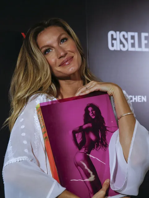 Brazilian model Gisele Bundchen poses for pictures with her book, titled Gisele Bundchen, dedicated her 20-year modeling career, prior to signing autographs in Sao Paulo, Brazil, Friday, November 6, 2015. (Photo by Andre Penner/AP Photo)