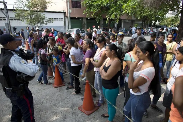 Relatives of prisoners wait to hear news about their family members imprisoned at a police station where a riot broke out, in Valencia, Venezuela, Thursday, March 29, 2018. The attorney general, Tarek William Saab, said last night that 68 people were killed in a fire that took place in the dungeons of the central police headquarters in the central state of Carabobo on Wednesday. Among those killed were two women who were per noting in the facility, Saab said without offering more details. (Photo by Ariana Cubillos/AP Photo)