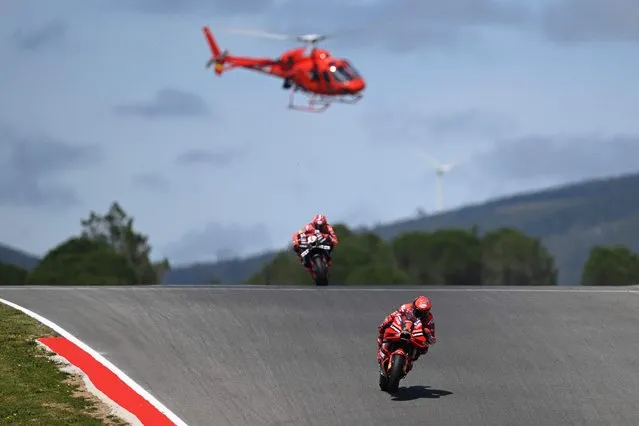 Ducati Italian rider Francesco Bagnaia (bottom) and Aprilia Spanish rider Maverick Vinales compete in the MotoGP race of the Portuguese Grand Prix at the Algarve International Circuit in Portimao, on March 26, 2023. (Photo by Patricia De Melo Moreira/AFP Photo)