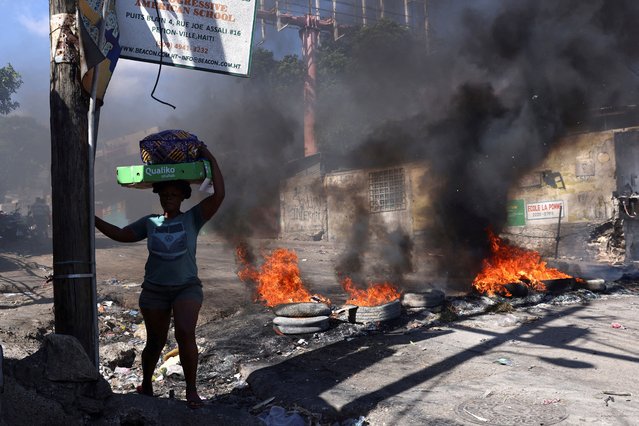 A woman walks past a burning barricade set during a protest against insecurity, in the Petion-Ville neighborhood of Port-au-Prince, Haiti on April 2, 2025. (Photo by Ralph Tedy Erol/Reuters)