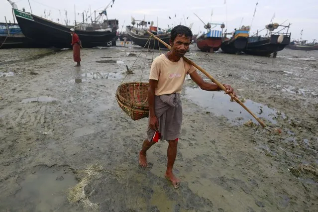 A Muslim Rohingya man carries a basket near the fishing port at a refugee camp outside Sittwe October 29, 2015. (Photo by Soe Zeya Tun/Reuters)