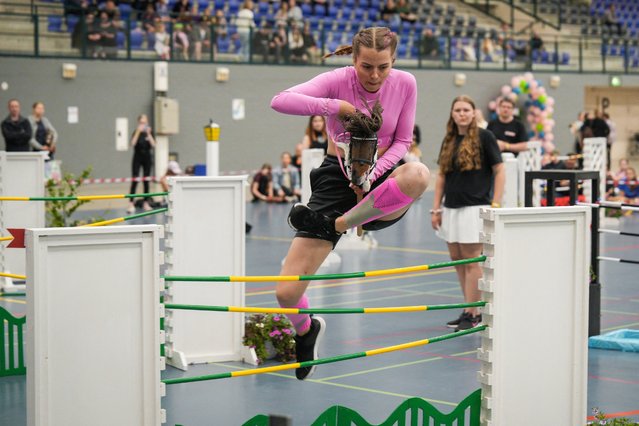 A participant competes in the show jumping category of the Finnish Hobbyhorse Championships 2024 at the local sport arena in Seinäjoki, Finland on June 15, 2024. The world's biggest hobby horse event organised in Finland is seeing more devotees every year despite ridiculing attitudes surrounding the hobby which might seem odd at a first glance. Hobby horsing initially sprung out of Finland as a phenomenon over 10 years ago and has since gathered an increasing number of enthusiasts in the Nordic country and abroad. (Photo by Alessandro Rampazzo/AFP Photo)