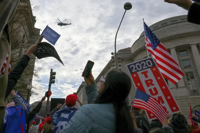 Marine One, carrying U.S. President Donald Trump, passes over people attending a rally to protest the results of the election in front of Supreme Court building, in Washington, U.S., December 12, 2020. (Photo by Jonathan Ernst/Reuters)
