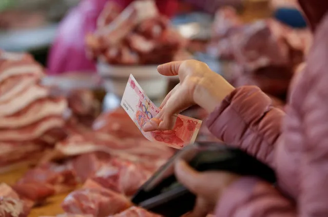 A customer pays a vendor at a market in Beijing, China, March 25, 2016. (Photo by Jason Lee/Reuters)