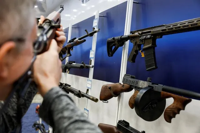A man tries out a rifle at the National Rifle Association (NRA) annual convention in Indianapolis, Indiana, U.S., April 14, 2023. (Photo by Evelyn Hockstein/Reuters)