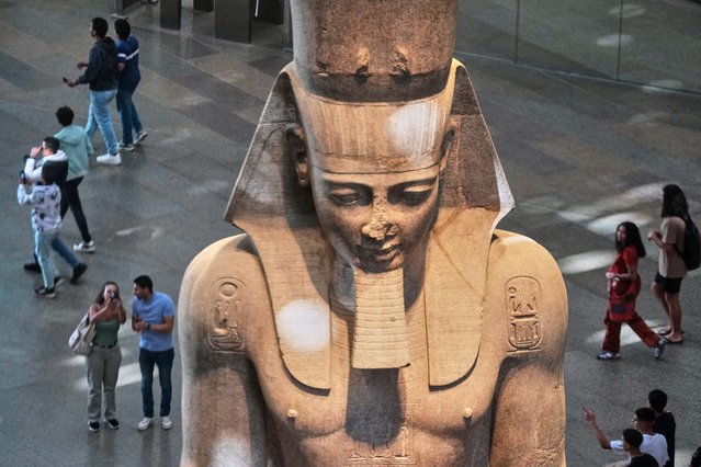 Tourists view the statue of Pharaoh Ramses II, during the first day for visitors after the official opening of the Grand Egyptian Museum in Giza, Egypt, Tuesday, November 4, 2025. (Photo by Amr Nabil/AP Photo)