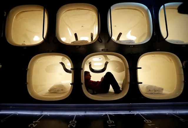 A guest takes a rest in his room at Japan's capsule hotel chain nine hours' Shinjuku-North branch in Tokyo, Japan, April 13, 2018. (Photo by Kim Kyung-Hoon/Reuters)