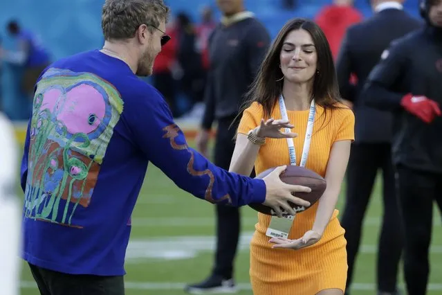 Actress and model Emily Ratajkowski takes a handoff on the field before the NFL Super Bowl 54 football game between the San Francisco 49ers and Kansas City Chiefs Sunday, February 2, 2020, in Miami Gardens, Fla. (Photo by Matt York/AP Photo)