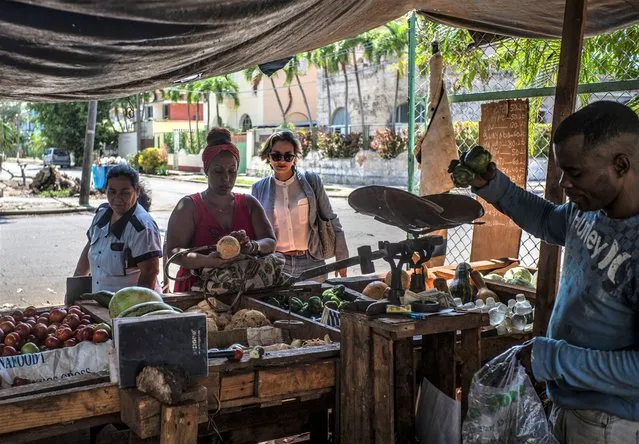 Congressional candidates Denisse Ricardo, stops at a vegetable stall while campaigning in Havana, Cuba, Tuesday, March 21, 2023. Some eight million Cubans will vote on Sunday, March 26, for the deputies that will make up the People's Power National Assembly, a unicameral parliament. (Photo by Ramon Espinosa/AP Photo)