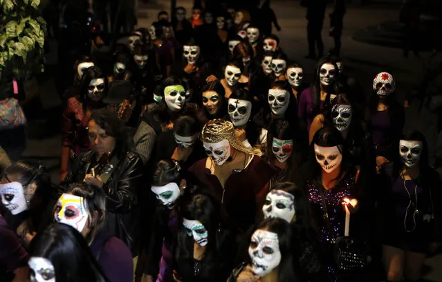 Sеx workers, wearing decorative skull masks, march through the streets in downtown Mexico City, Friday, October 28, 2016. The women march with candles to an altar dedicated to their departed colleagues, many who died violently at the hands of their customers. This annual procession, tied to the Day of the Dead festivities, has taken place for more than 20 years. (Photo by Eduardo Verdugo/AP Photo)