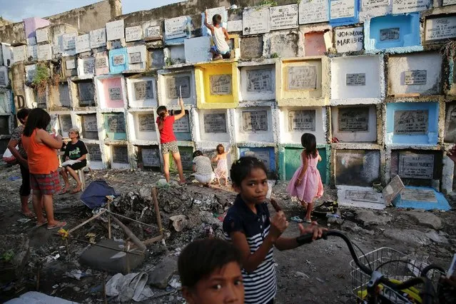 People visit tombs of their loved ones ahead of the commemoration of All Saints day at Navotas Public cemetery in Manila, Philippines, October 31, 2016. (Photo by Damir Sagolj/Reuters)