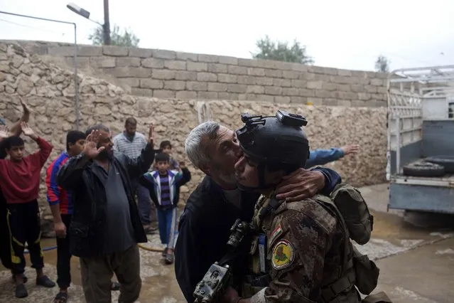 A man kisses an Iraqi special forces soldier after his house was searched, in Gogjali, an eastern district of Mosul, Iraq, Wednesday, November 2, 2016. (Photo by Marko Drobnjakovic/AP Photo)