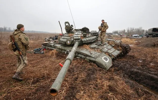 Ukrainian service members inspect a stuck Russian tank, as Russia's attack on Ukraine continues, in the village of Nova Basan, in Chernihiv region, Ukraine on April 1, 2022. (Photo by Serhii Nuzhnenko/Reuters)