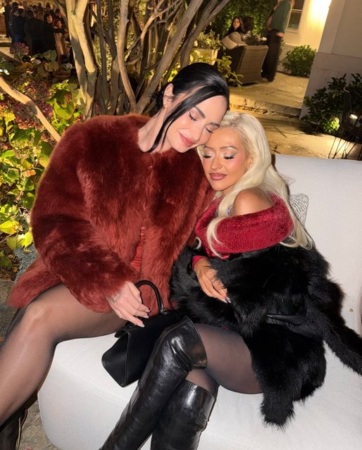 American singers Demi Lovato and Christina Aguilera cuddle up at a holiday party in the second decade of December 2025. (Photo by ddlovato/Instagram)