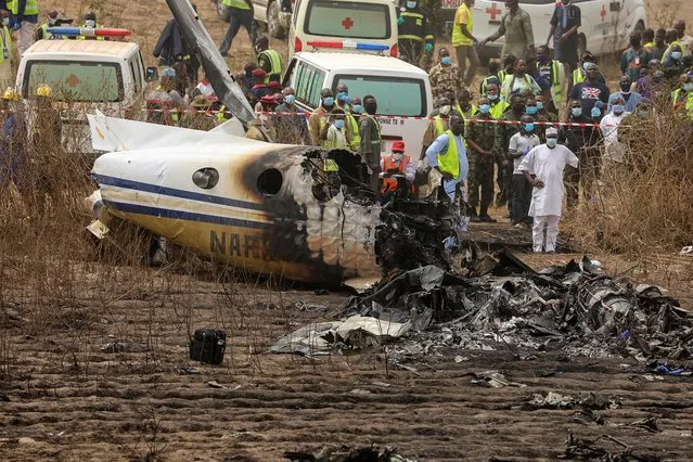 Rescuers and people gather near the debris of a Nigerian air force plane, which according to the aviation minister crashed while approaching the Abuja airport runway, in Abuja, Nigeria on February 21, 2021. (Photo by Afolabi Sotunde/Reuters)