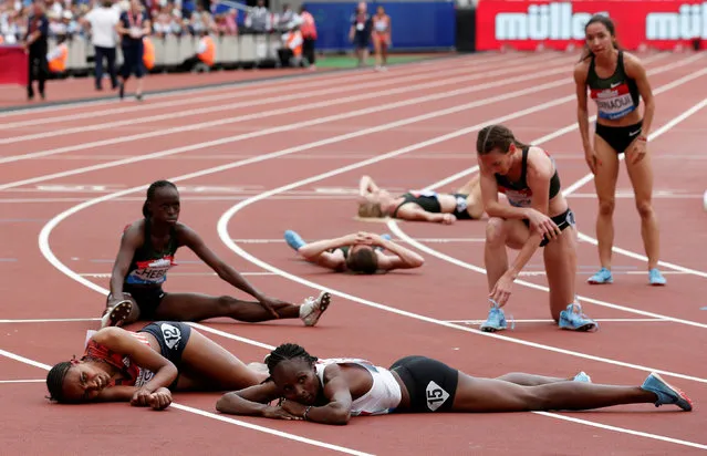 Athletes collapse after finishing the Women' s 1 mile event during the anniversary games at the Queen Elizabeth stadium in London on July 22, 2018. (Photo by David Klein/Reuters)