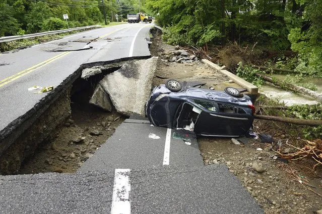 A damaged car lays on a collapsed roadway along Route 32 in the Hudson Valley near Cornwall, N.Y., Monday, July 10, 2023. Heavy rain has washed out roads and forced evacuations in the Northeast as more downpours were forecast throughout the day. (Photo by Paul Kazdan/AP Photo)