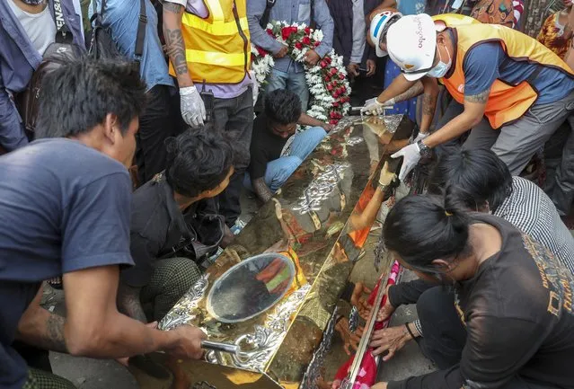 The body of Saw Pyae Naing is placed in a coffin in Mandalay, Myanmar, Sunday, March 14, 2021. (Photo by AP Photo/Stringer)